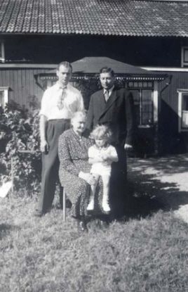 En familj som står framför ett hus