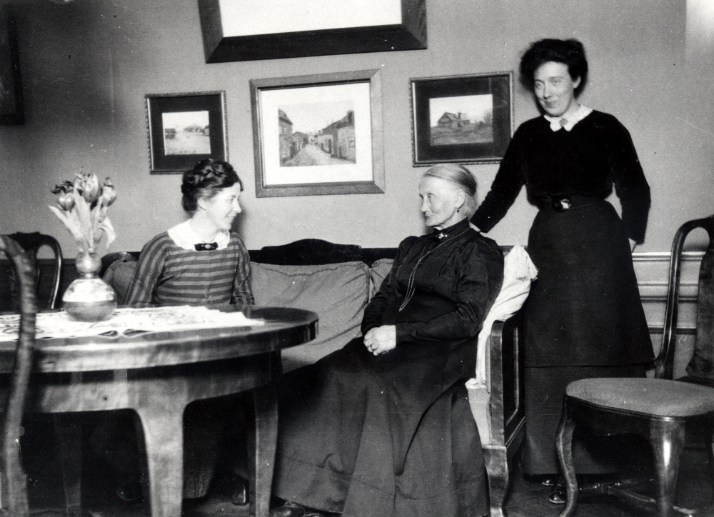 Johanna Carlsson med döttrarna fr v Hanna och Jenny i salen på Väsby gård i Vallentuna.  På bordet stå en vas med tulpaner.  Hanna donerade Väsby gårds kvarn till Vallentuna hembygdsförening 25 maj 1959.  Johanna var gift med B C Carlsson, byggmästare från Jönköping som köpte Väsby gård 1906