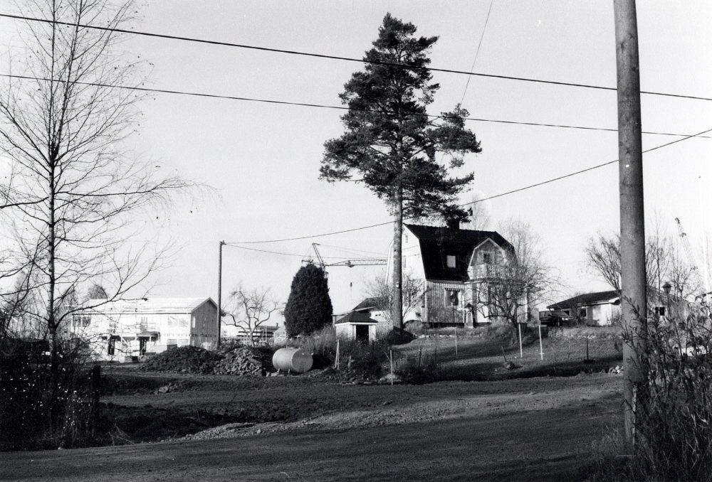 Huset Sveaborg finns kvar när bostadsområdet Haga byggs i hörnet av Lindholmsvägen och Lingsbergsvägen. Fotograferat från Lingsbergsvägens nya sträckning strax öster om Lindholmsvägen. Bland den nya bebyggelsen finns några gamla fastigheter kvar. T v syns Haga-husen under uppförande