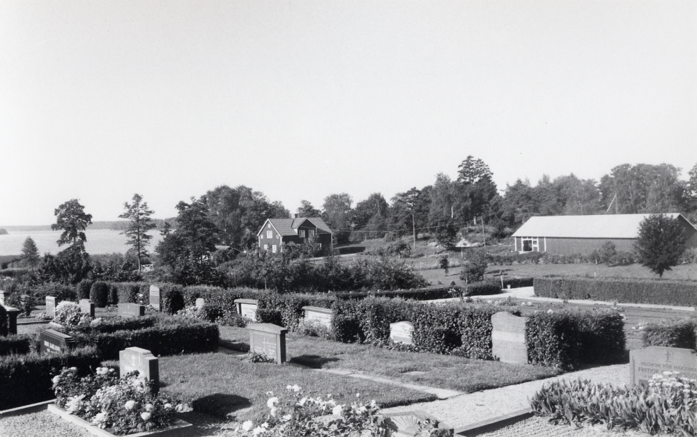Vallentuna kyrkogård med Sjövillan och Kyrkviken i Vallentunasjön i bakgrunden