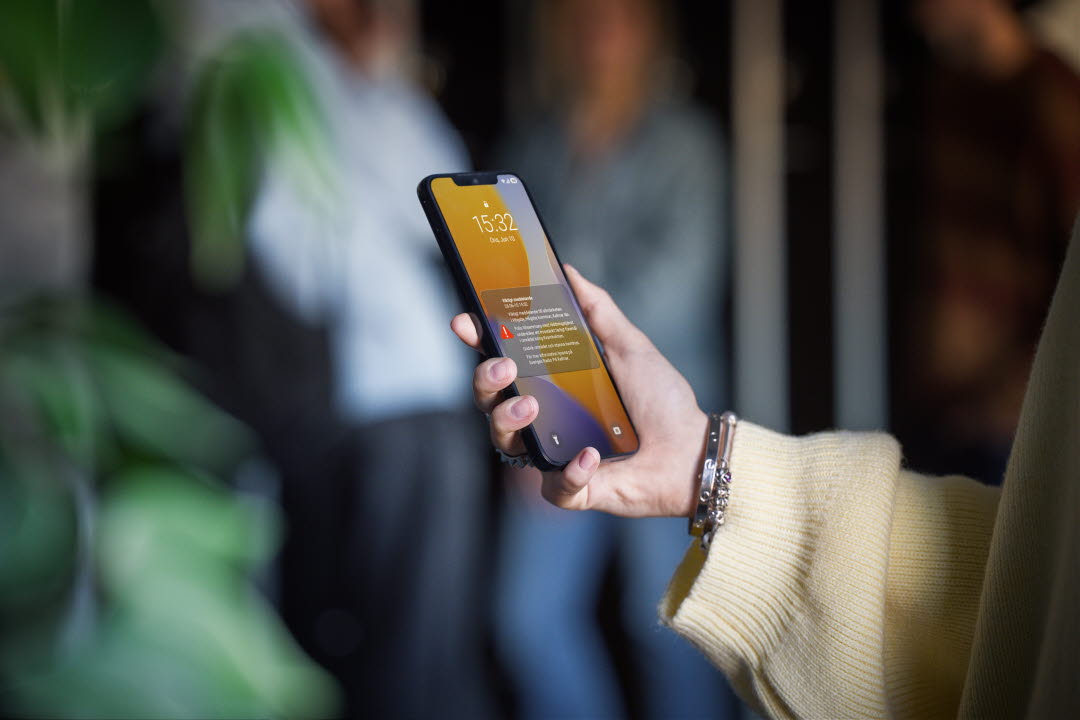 En hand som håller en mobiltelefon.