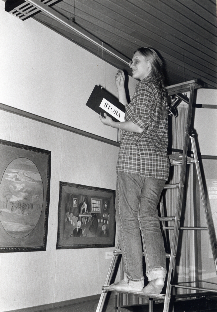 1700-tal i Vallentuna – en utställning i Vallentunasalen.  Susanna Detthoff sätter upp skyltar i taket till utställningen i Vallentunasalen – producerad av Vallentuna kulturförvaltning i samarbete med hembygdsföreningarna i Vallentuna och Historiska museet