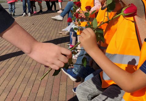 Ett barn som ger en ros till ett annat barn