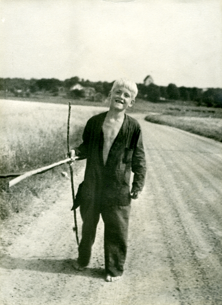 Sven-Erik Karlsson på väg att meta i Vallentunasjön.  Sven-Erik, son till Väsby gårds arrendator Sven Karlsson och hans hustru Märta, står på vägen mellan Vallentuna kyrka och Väsby gård, nuvarande Gamla Väsbyvägen.