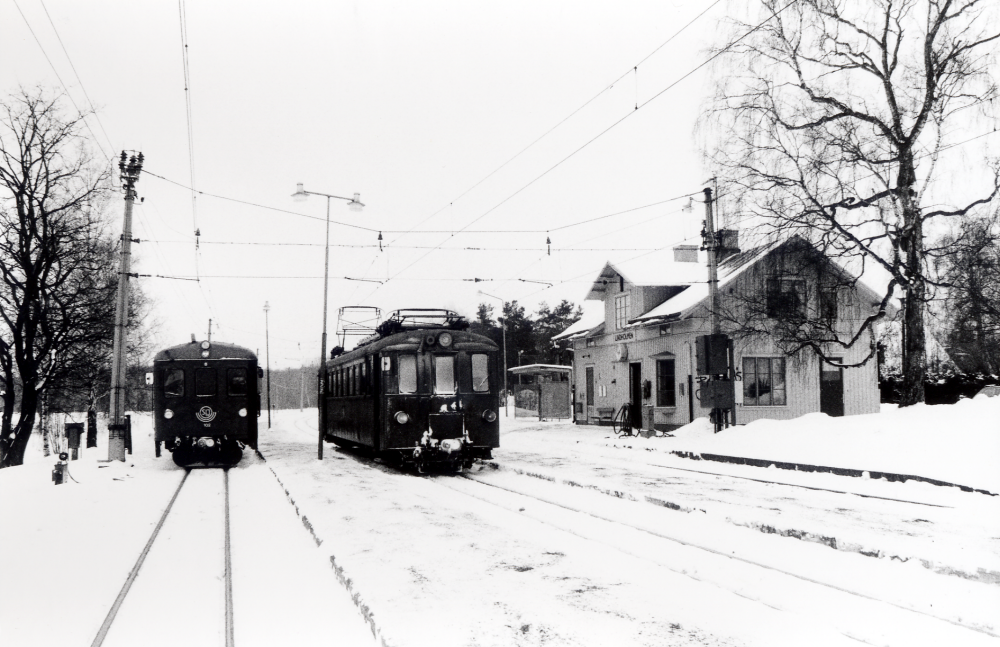 Lindholmens järnvägsstation.  T h står motorvagn 37, som pendlar mellan Lindholmen och Kårsta.  T v  står vagnarna 55, 925 och 102 på väg söderut mot Stockholm Östra