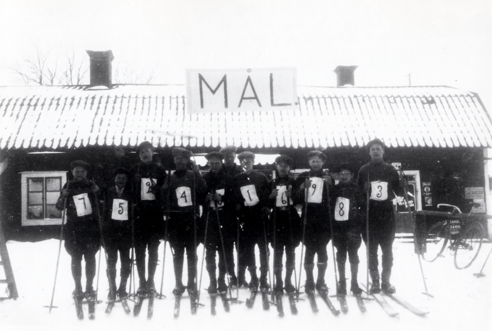 Brottby SK. Skidtävling med mål vid Brottby handelsbod.  Fr v Valter Andersson, Torvald Eriksson, Sven Andersson, Harry Högberg, Valter Dahlbeck, Nils Alstermark, Georg Dahlbeck, Gunnar Dahlbeck, Sven Nordin, Axel Andersson och Valter "Bagarn" Andersson
