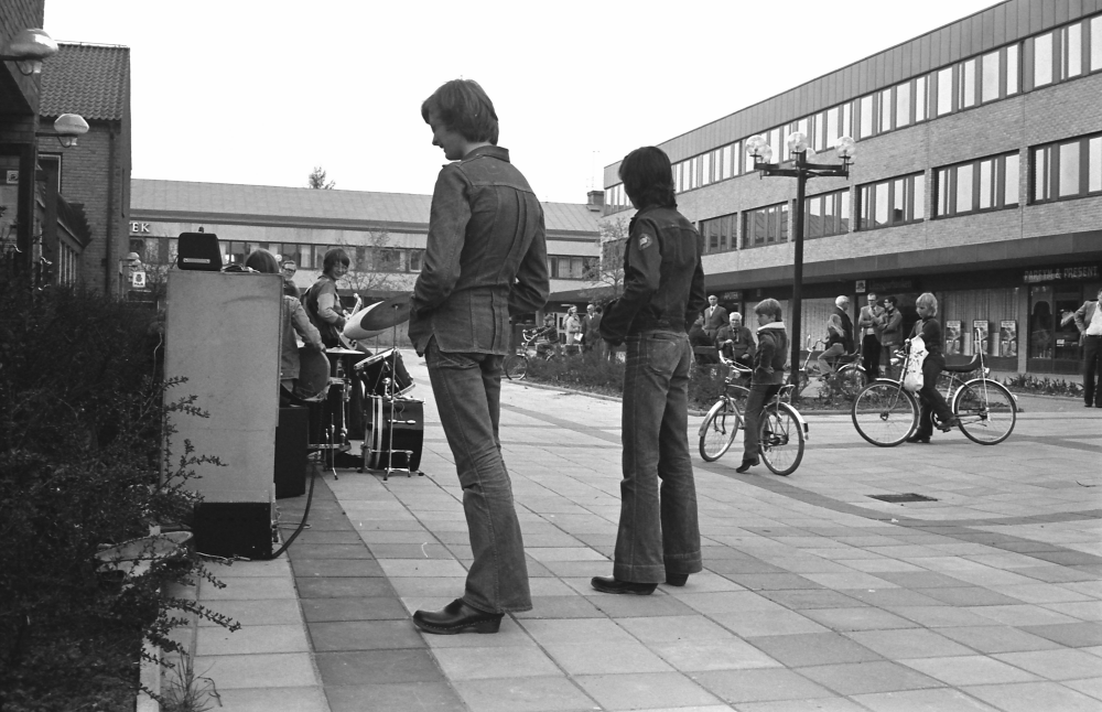 Tuna torg 1976 med Tunahuset till höger och Torghuset i bakgrunden till vänster.
•Fotografiet ingår i bildserien ”Vardagsliv i Vallentuna kommun” av Rachael Gough-Azmier & Gunilla Blomé, Haga Studios HB.
