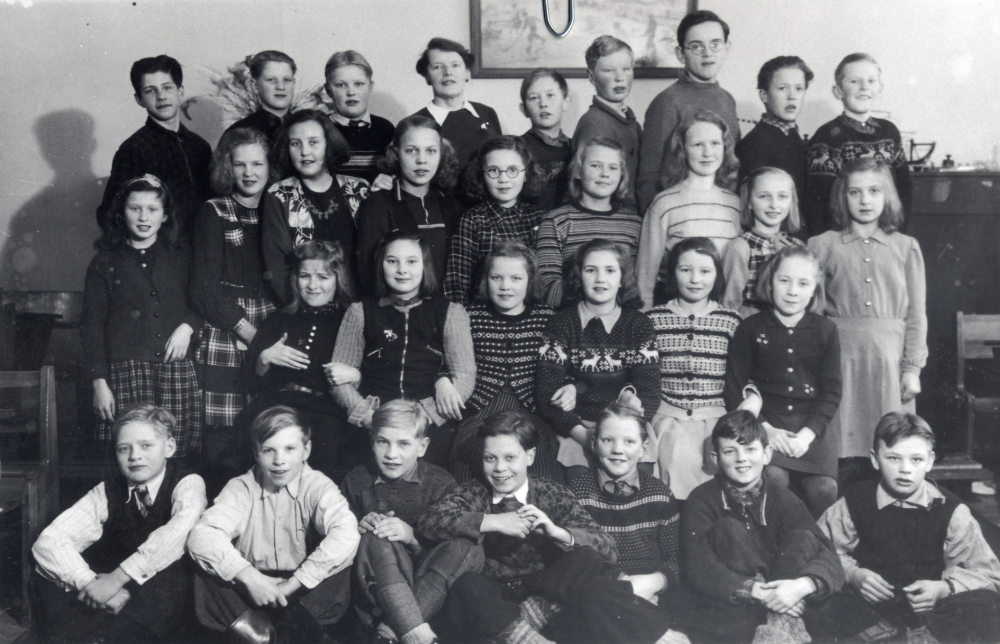 Lärarinnan Edit Lindström med elever i klass 6, Hjälmsta skola.  I bakre raden står fr v Bertil Berg/Trost, Sven-Erik Lundqvist, Olle "Bull" Andersson, Edit Lindström, Nerland Andersson, Georg Höglund, Erik Sonmarin, Stig Kvick och Bengt Johansson.  Andra raden fr v  Anna-Greta Kvick, Siv Warsau, Britt Lundin, Gudrun Mård?, okänd, Ulla Bergström, okänd, Siv Jonsson och Ulla-Britt Hoff.  Sittande rad 3  okänd, okänd, Siv Bergqvist, Siv Bergvall, Anna-Lisa Magnusson Bällsta och Ingrid Lundkvist (Lund).  Sittande fr v Stig Österberg, okänd, Sven Johansson, Åke Tillborg, Anders Karlsson, ? Ernström och Rune Lutteman.