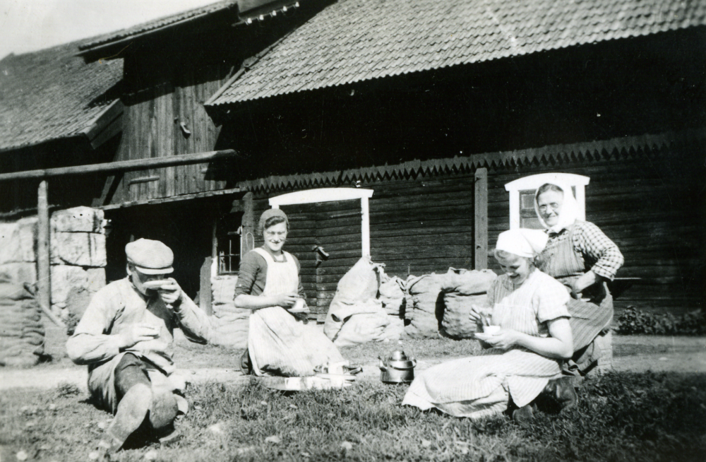 Framför stallet och höskullen har man tagit kafferast på Saxta gård. Från vänster sitter Sven Andersson född 1918, Ada Andersson (senare Pettersson), Elsa Andersson och Signe Andersson. Signe och Oskar Andersson ägde och brukade gården 1918 -1957. Se vidare i boken Historia och minnen i Markim s.134f.