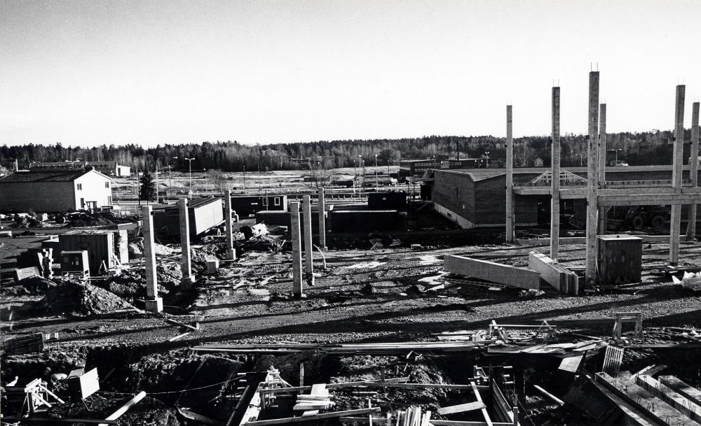 Förvaltningshuset Tärningen byggs. Stommen har rests. Bakom betongstolparna t h syns det nya Domus. T v syns Centrum-Bio och bakom det huset bebyggelsen på Åby gärde