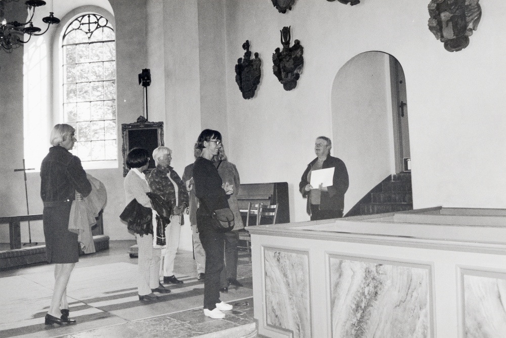 Kulturombuden i vården gör ett studiebesök i Vallentuna  kyrka.  Fr v deltar Anna Brynell, Vallentuna bibliotek och besökets arrangör, Grethel Hofgren, Kajsa Skoog, Lotta Zackrisson,  Cecilia Tholstrup-Ernö, två personer är skymda. Vid trappan till sakristian står guiden kyrkvaktmästare Britten Andersson