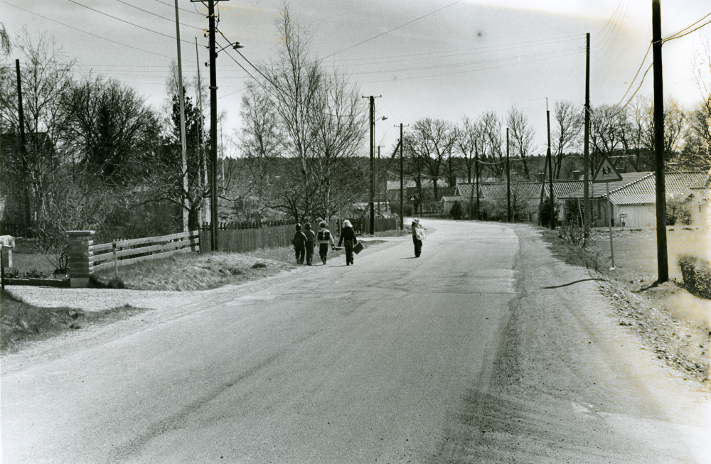 Fem små skolbarn med skolväskor promenerar på vägen mot Ormstaskolan.
•Fotografiet ingår i bildserien ”Vardagsliv i Vallentuna kommun” av Rachael Gough-Azmier & Gunilla Blomé, Haga Studios HB.