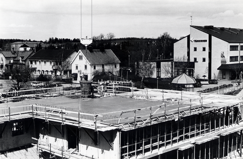 Vallentunas nya kommunalhus byggs sedan den gamla byggnaden rivits.  Gjutningsarbeten pågår över våningsplan ett.  JM Bygg bygger.  T h syns Tärningen med Paviljongen och beyggelse utmed Allévägen