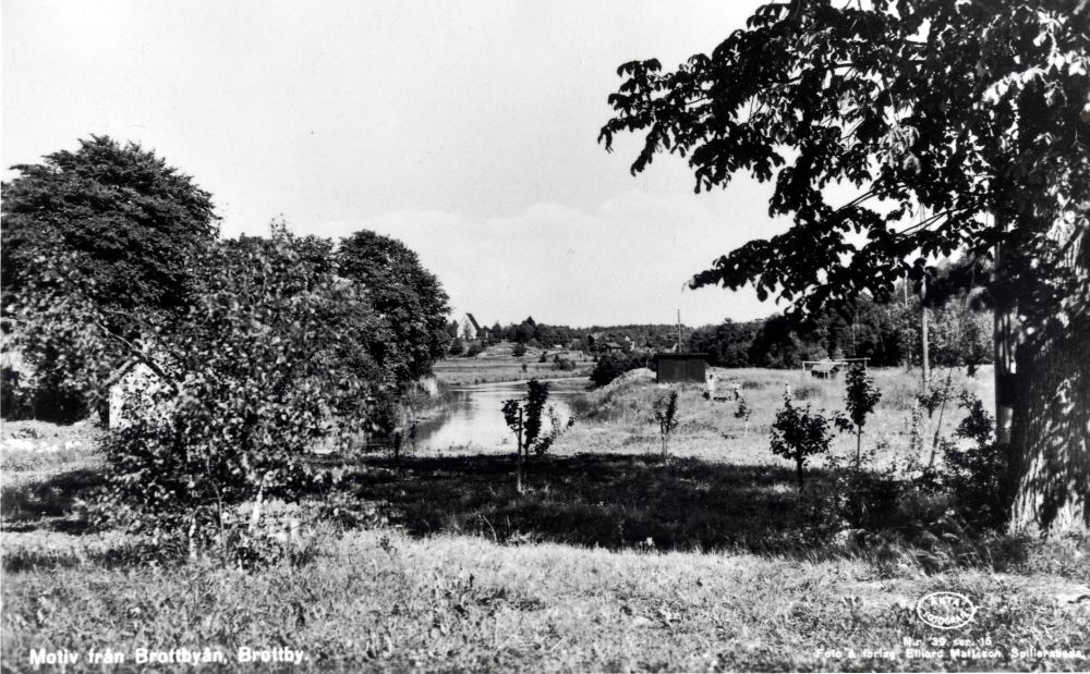 Motiv från Brottbyån.  I bakgrundens syns Össeby-Garns kyrka, Klockstapeln och bebyggelse i Lilla Garn