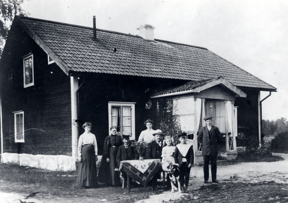 Granby gård. Fr v en jungfru, Amanda Pettersson och Albert Pettersson, gårdens brukare, en jungfru, okänd man med två barn, sonen Edvard Pettersson. Edvard tog senare namnet Regny och arbetade på Packard hyrverk i Stockholm. Gårdens fastighetsbeteckning: Össeby-Granby 5: 11