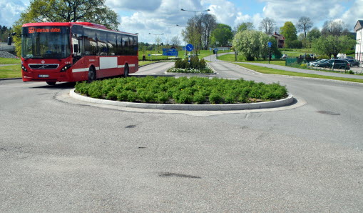 Åtta barn framför gul skolbuss. 
