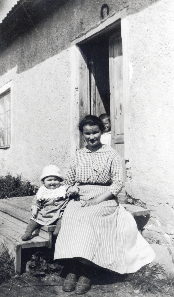 Helga Hedlund på trappan till mjölnarstugan vid Mörby kvarn i Lunda där maken Werner var mjölnare.  Senare samma år flyttade familjen till Granby kvarn och såg i Orkesta.  Bredvid på trappan sitter sonen Robert.  I dörren står sonen Holger Arne som senare dog i difteri