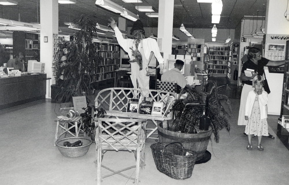 Trädgård - en miniutställning i Vallentuna bibliotek med träkar och pump med rinnande vatten samt trädgårdsböcker. Sommaren 2000 pågick en trädgårdsutställning i Vallentunasalen.  Även då användes Ingrid Rosts gamla trädgårdsmöbler tillverkade av grenar.  T v står Lina, dotter till bibliotekarien Eva-Lena Granbacka