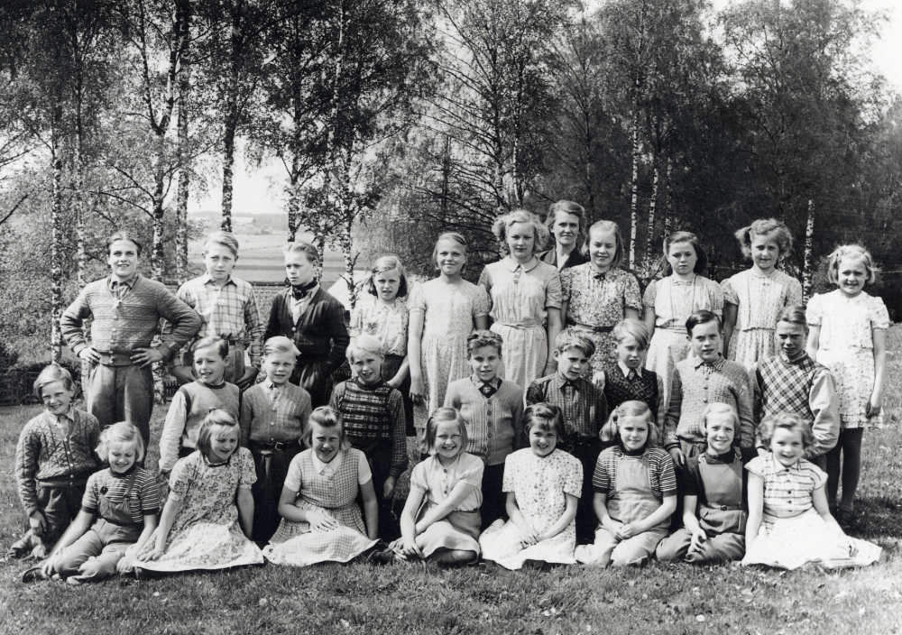 Lärarinnan Signe Andersson tillsammans med skolbarnen vid Åvasta skola.  I bakre raden står fr v Gert Zackariasen, Lasse Eriksson, Kurt-Roland Jansson, Maj Johansson, Eivor Dahlberg, Rut Nilsson,  Siv Söderström,  Lillemor  Jansson, Desiré Andersson, Maud Söderström.  Mittenraden fr v okänd,  Fredriksson,  Rolf Arne Jansson,  Arne Jansson, okänd, Hans Jansson, Bo Lundin, Bjarne Zackariasen och Nisse Johansson.  Tredje raden fr v Gerd Pettersson, Siv Nilsson, Ulla Pettersson, Gun- Mari Karlsson, Mona Sahlberg, Siv Pettersson, Margareta Jansson och Irène Jansson