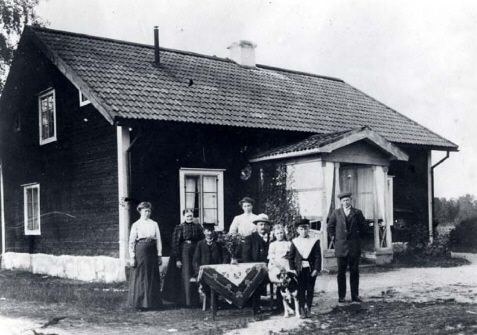 Grupp människor som står framför ett hus