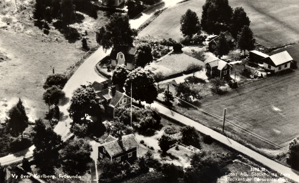 Flygfoto över Karlbergs affär i Frösunda.  Affärshuset ligger vid vägen mot Kårsta i korsningen med Gottröravägen.  Siste innehavare var Sigvard Jansson, född 19911, död 2005.  Affären lades ner 1973.  Vykortet är poststämplat 14.7.1968