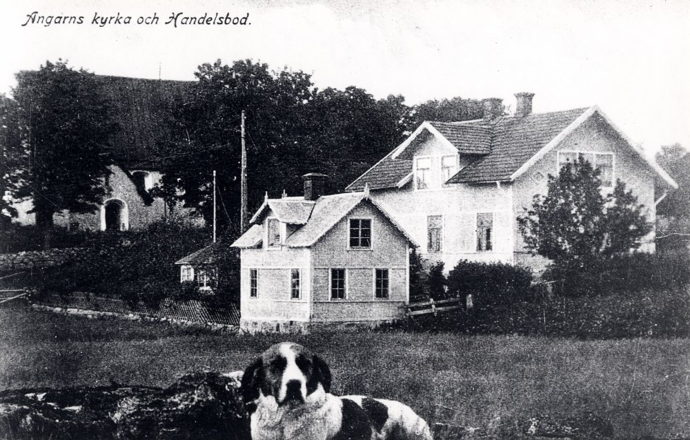 Karlborgs handelsbod  med  Angarns kyrka  t v.  I  förgrunden står en  hund