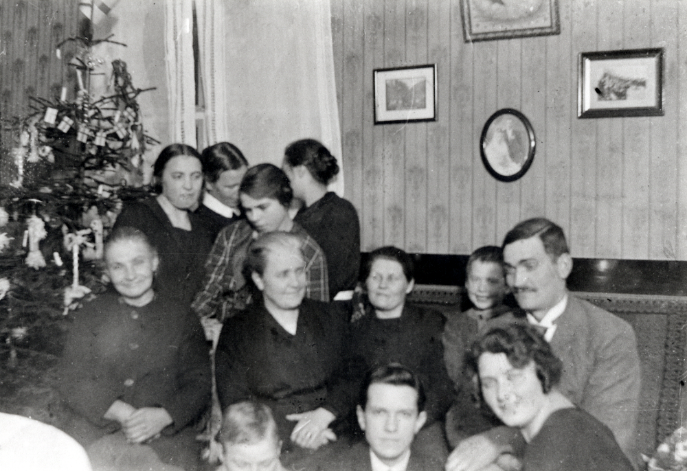 Vid juletid har man samlats hos Henning Larsson i Byle. T v står julgranen. På golvet sitter fr v Karl Erik Söderberg f 1913, predikanten (bönemöte?) och Anna-Lisa Waldebäck. I mittenraden fr v Elin Persson (Gustaf Åkerbloms fostermor) 1866-1944, Gunhild Waldebäck f ca 1870, Eva Jansson f 1895, Gustaf Åkerblom f 1918 och Henning Larsson f 1895. Längst bak fr v Barbro Waldebäck f 1907, Edla Österwall, Greta Larsson, född Fridh-Jansson 1910 och Signe Larsson f 1900, Hennings fru.