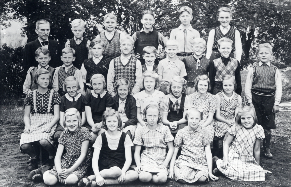 Läraren Vilhelm Kant tillsammans med skolbarnen utanför Markim-Orkesta skola. Bakre raden fr v Kurt Ehrman, Sivert  Karlsson, Karl-Erik Björkman, Åke Andersson, och Bert Lindström, Rad 2: Arne Lundkvist, Rune Persson, Sture Lindkvist, Bertil Melkersson, Herman Lindkvist, Rune Hjalmarsson, Karl-Erik Jansson, Folke Thunberg, och Allan Jansson  Rad 3: Aina Andersson, Ulla Åhlén, Rosa Åhlén, Kerstin Rosén, Gerd Forsberg, Gurli Larsson, Elvy Häll, och Gun Ström. Rad 4: Alice Samuelsson, Maj-Britt Jansson, Anna-Greta Lundkvist, Asta Eriksson och Ulla Andersson