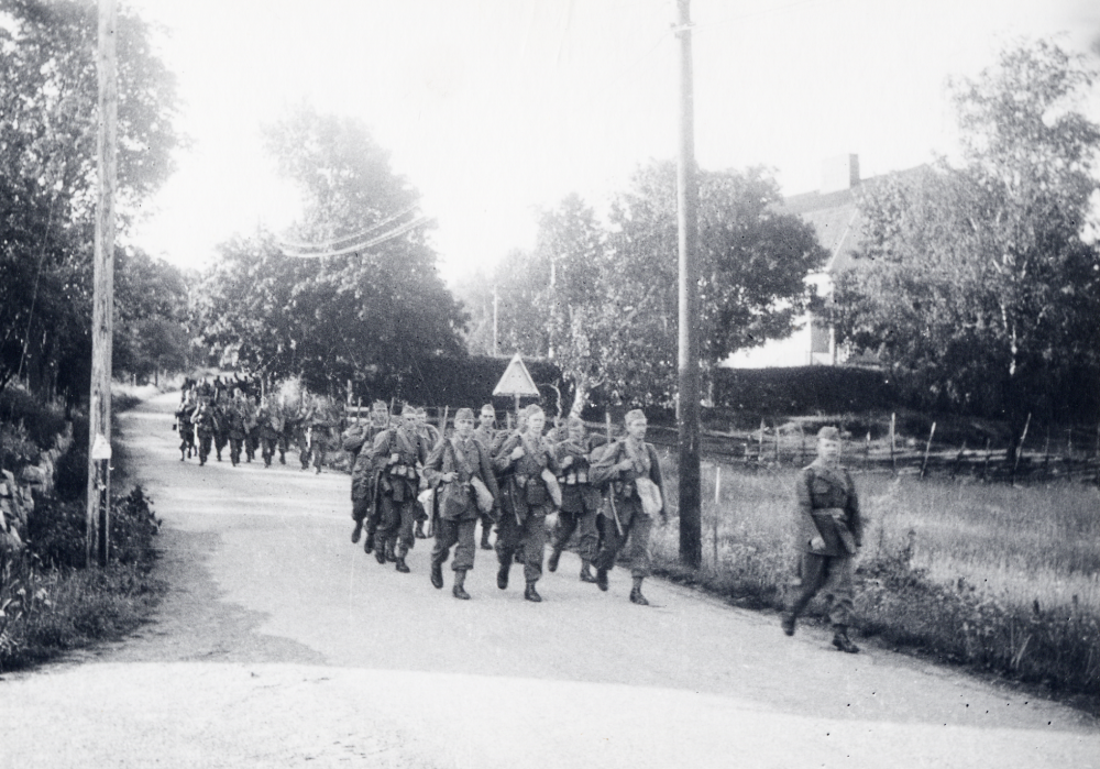 Rimbo skolkompani  utrustas vid  landstormsförrådet nr 46  vid  Hjälmsta skola  vid  mobiliseringen  1939. Här tågar manskapet ner förbi  Vita skolan  på  Skolvägen