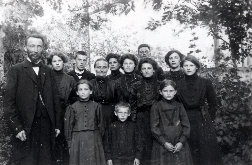 Skomakare K P Gustafsson tillsammans med hustrun och elva barn i Finsta innan de flyttade till Vallentuna och Allévägen 8.  De tre mindre barnen fr v Ruth, hade telefonstationen på Allévägen 8, Ernst, och Hildegard som dog 1912.  I bakre raden fr v KP själv, Mimmi (gift med Sixten Palmblad, Cyrus, hustrun Hilda, Ester, Jenny, Ingeborg gift med Martin Kock,  Fritiof skomakare på Banvägen och gift med Ester, Beda och Anna gift Lindvall.  Den minsta pojken Ernst gifte sig med Anna-Lisa och övertog Palmblads affär i korsningen Skolvägen och dåvarande Stockholmsvägen på 1930-talet