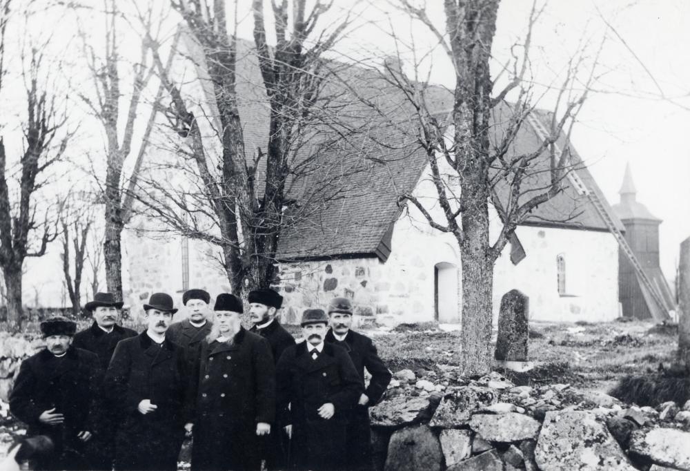 Frösunda kyrkoråd samlat utanför Frösunda kyrka. I bildens mitt med vita polisonger står kyrkoherde C M Anjou och i plommonstop fotografen Zackeus Carlsson