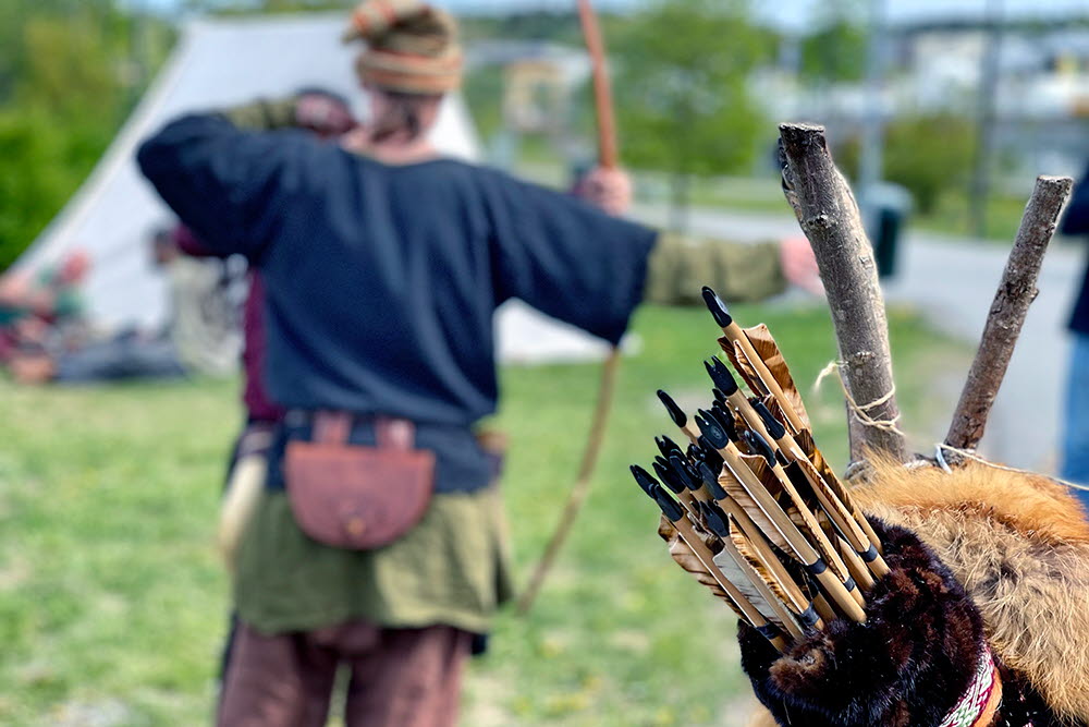 Person med pilbåge i handen, koger i förgrunden