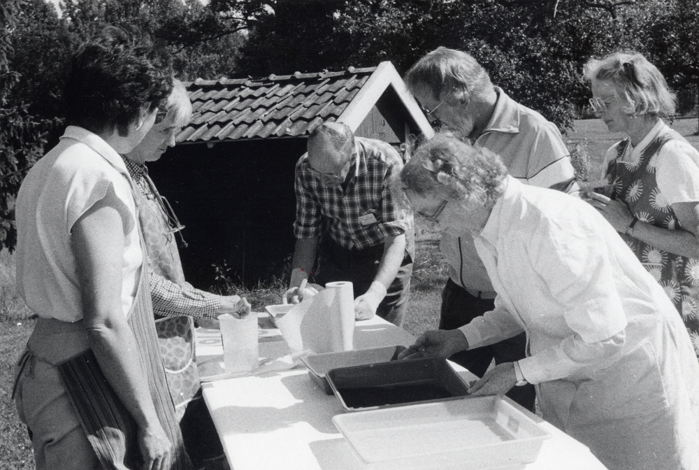 Gun Hillbo  från  Vallentuna bildarkiv  deltar i kursen  Rädda bilden  på  Ransbergs herrgård  i Värmland 3-8 augusti. Kursledare var Irene Mattsson från Malung. Här provas olika kemiska bad för blekning och isärtagning av glasplåtar. Fr v  Margareta Johansson  Bollnäs,  Annette Stenbäck  Hagfors,  Henry Persson  Tjällmo,  Jan Evert Källviks  Hedemora  Margit Hammarberg  Skene. I vit rock kursledaren  Irene Mattsson  som ocksa hade sin man  Evert Mattsson  till hjälp