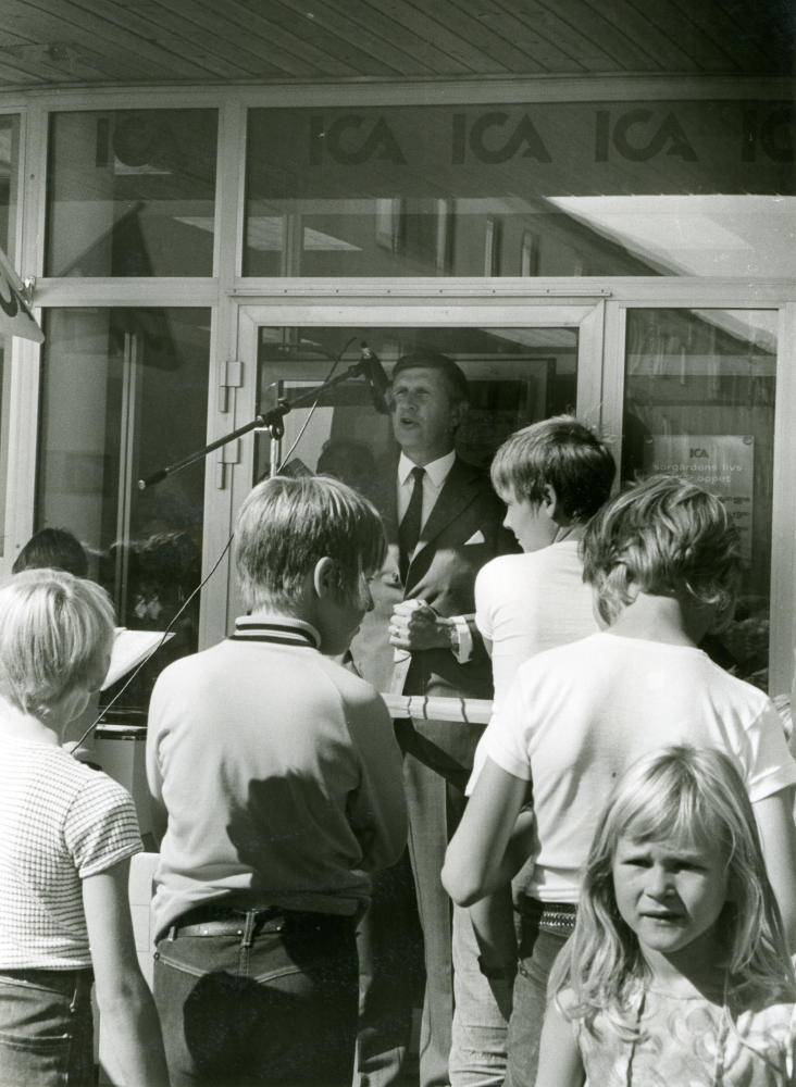 Kommunalrådet Ingvar Lidskog invigningstalar vid öppnandet av Sörgårdens kvartersbutik.

•Fotografiet ingår i bildserien ”Vardagsliv i Vallentuna kommun” av Rachael Gough-Azmier & Gunilla Blomé, Haga Studios HB.