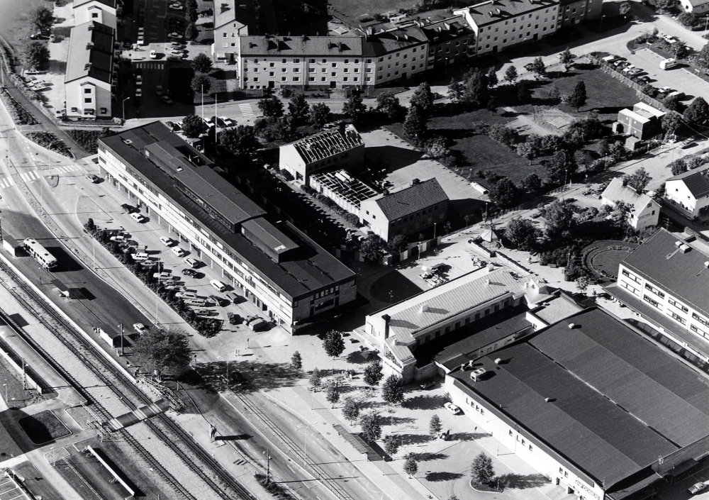 Flygfoto över Vallentuna centrum.  I förgrunden Roslagsbanan samt Banvägen.  Huset i mitten är Tunahuset, bakom det pågår rivningen av Vallentuna kommunalhus, ett nytt kommunal skall byggas på samma plats. Th syns Domus varuhus och bakom det centrumhuset Tärningen med bl a bibliotek och försäkringkassa. Längst t v bostadshus längs Centralvägen och Skördevägen