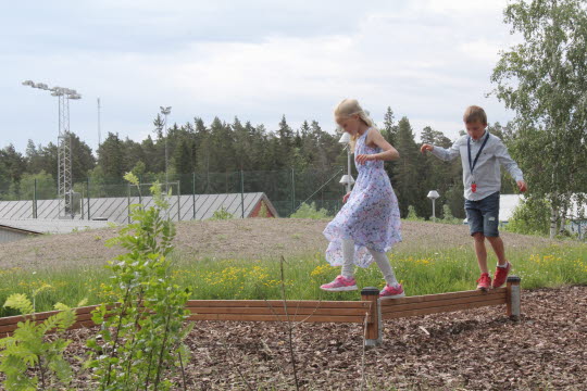 Två barn som balanserar på en spång