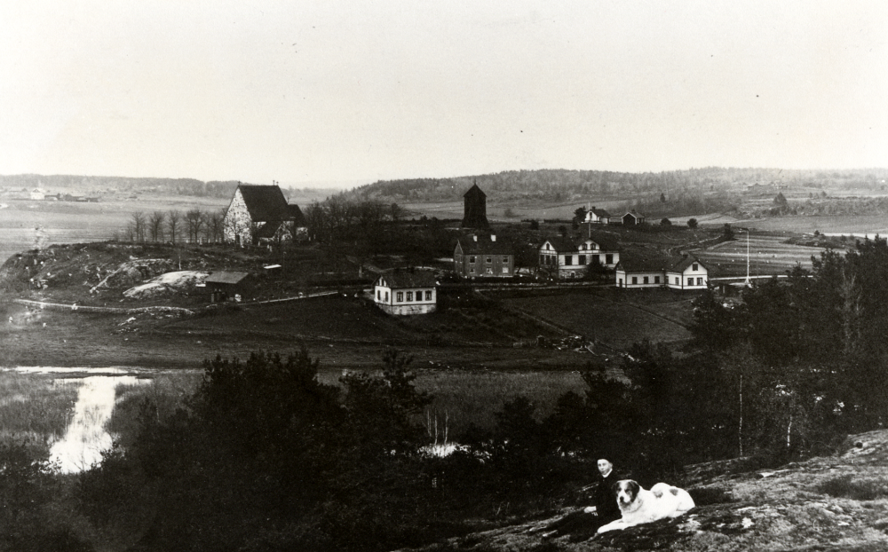 Lilla Garns kyrkby i Össeby-Garn.  

Kopia av vykort vars text lyder: Toftesta den 4/12 1905.  Kära lilla Ester tack för allt besvär du haft för min skull! Tyckte det var roligt att skicka detta kort till dig.  Hoppas Du känner igen det.  Många hälsningar från oss alla din vän Maja (Maria Almén till sin svägerska på Olofsgatan 3 i Stockholm, poststämplat med ångbåt ...5 december 1905)
