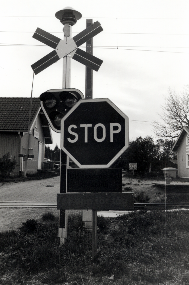 Molnby anhalt med nya järnvägsbommar vid Molnbyvägen, en olycksdrabbad korsning.  Under stopptecknet finns tilläggstavlor med texten "Olycksdrabbad korsning" och "Se upp för tåg"