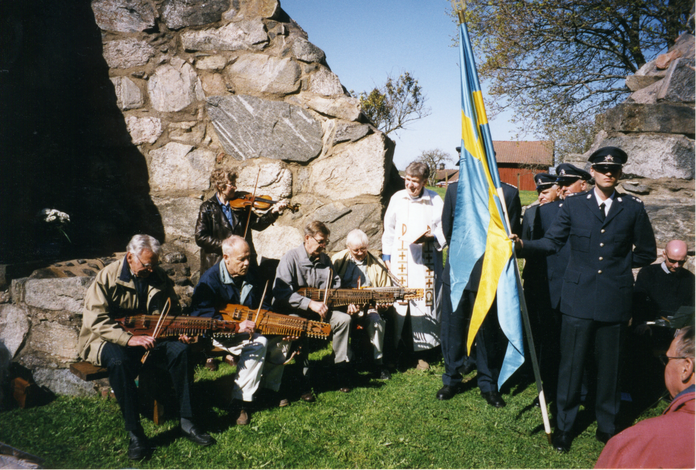 Kristi himmelfärds dag den 9 maj 2002 firas i Össeby kyrkoruin i Brottby. Prästen Sören Stadell med Vallentuna hemvärn som hedersvakt. Musikunderhållning med nyckelharpa och fiol. Svenska flaggan.
Foto och uppgifter: Fredrik Andersson.