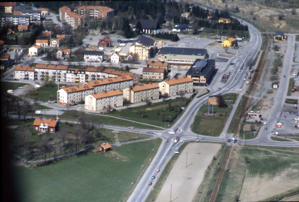 I bildens högra kant löper Åby gata och på andra sidan järnvägen Banvägen. I bildens mitt pågår uppförandet av det nya förvaltningshuset Tärningen.