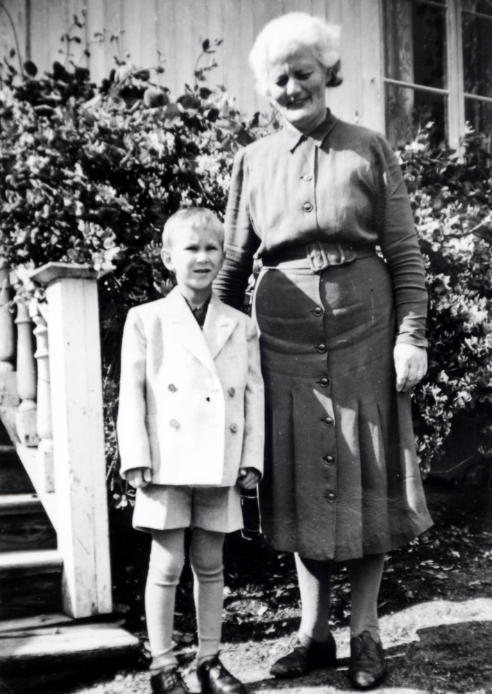 Inez och Manfred Ekholm köpte Ekskogen gård 1947.  Gården var i familjens ägo till 1965 då Manfreds avled. Timo och Inez står vid kökstrappan, med ingång till köket via glasverandan på manbyggnadens vänstra gavel. Timo har fått ärva kläderna efter Margareta Nygren, en liten flicka som avlidit. Ekskogens gård såldes 1965 till Åke Håkansson som ännu 2004 bor kvar där med sin familj.

Timo och hans lillebror Sami kom till Sverige som finska krigsbarn 1944. Timo adopterades senare av ägarparet på Ekskogens gård i Kårsta, Inez och Manfred Ekholm. Läs mer i Timo Ekholms bok Krigsbarn 40.