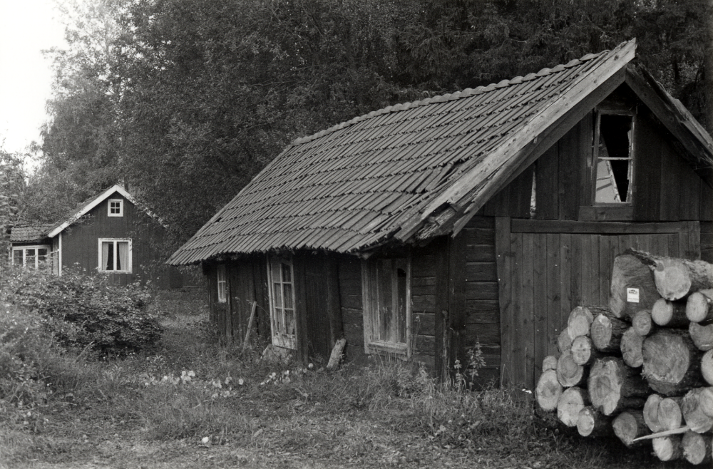 Gammal bebyggelse med liten lada och bostadshus på Lingsbergsvägens södra sida i Ormsta.  Huset kallades Joahnnesdal.  I huset bodde Karin Wandel 1954 till 1981.  Foto från 1982 strax innan husen revs och brändes ner