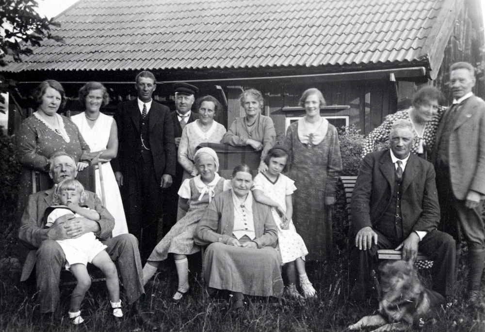 Familjefest med den årliga sommarmiddagen på Vada prästgård. Sittande fr v August Ahlén med sonsonen Gunnar Ahlén i knäet, Anna-Lisa Ahlén, fru Wester, Inga Wester och Karl Wester Stora Benhamra. Stående fr v Helga Ahlén, Britta Hellström, Gustav Wester, Helmer Ahlén, Anna Ahlén, Anna-Britta Hellström, Ragnhild Wester, Tyra Lund, Alfred 'Pelle' Lund och hunden Pelle-hund