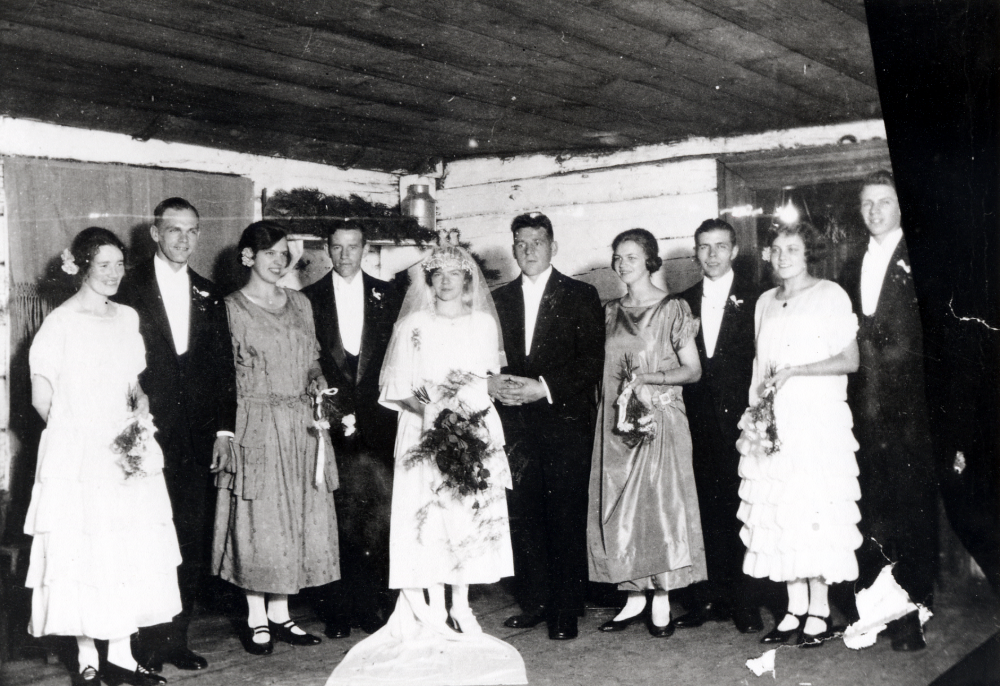Helga Helgöstam, Helgö gård och Holger Céwe, Karlberg har gift sig. Här står brudparet tillsammans med uppvaktning på Helgö gård.  Fr v Natalia Céwe och Fredrik Helgöstam (gifte sig senare), Karin Helgöstam, Allan Céwe, Helga och Holger Céwe, Svea Helgöstam, Uno Uddenberg, Rosa Forsmark och Gösta Helgöstam