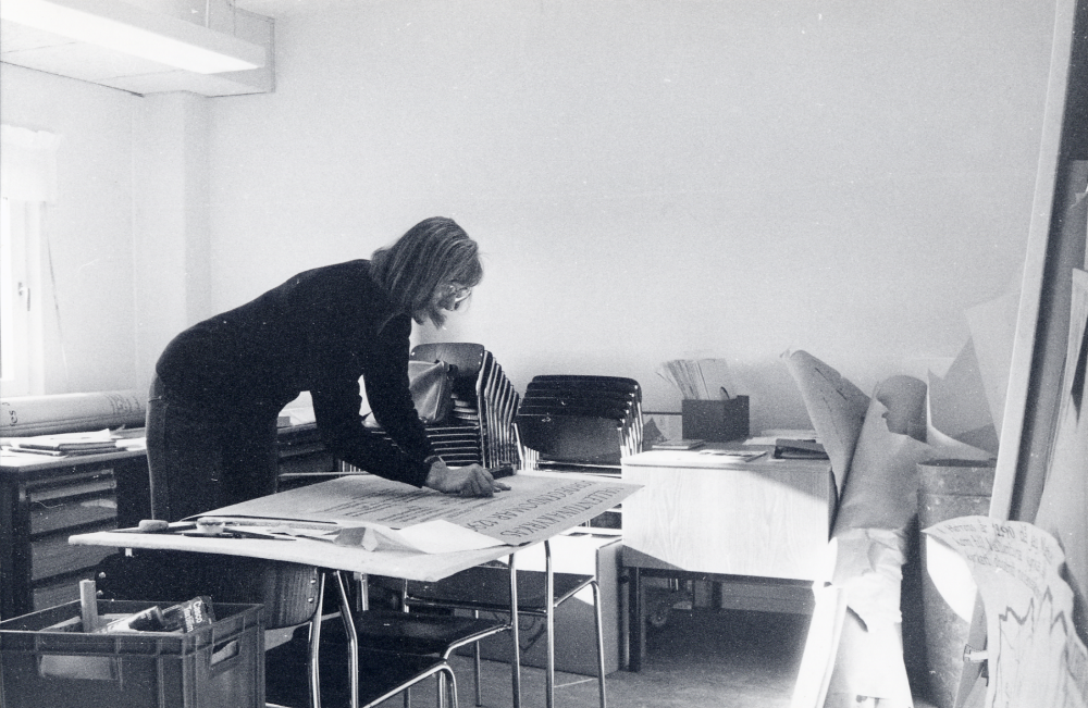 Gugge Plass-Rosenbaum textar alla texter till en utställning om Vallentunakalendariet, Sveriges äldsta bok, av Eva och Sigge Rahmqvist, utställd i Kulturfönstret 25 oktober - 14 november 1982. Foto i utställningsrummet i Vallentuna bibliotek i Tärningen