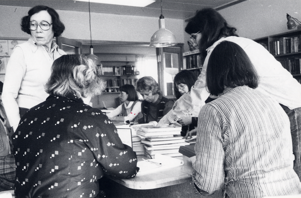 Personalmöte i Vallentuna bibliotek i de gamla lokalerna en trappa upp i nuvarande Torghuset. Efter mötet har personalen internutbildning med boklagning ledd av Ulla Mörk. Fr v med ryggen mot kameran Inger Olsson stående Ulla Mörk på andra sidan bordet fr v Pirkko Mickelsson Gunvor Svensson Ulla-Britt Kvarnestam Eva Rahmqvist och med ryggen mot kameran Margareta Dethorey