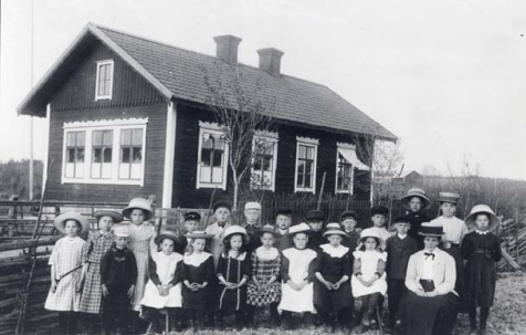 Barn som står framför en skolbyggnad