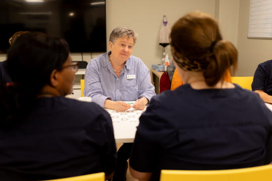 Anna-Lena håller i språkutbildning med deltagare som sitter runt ett bord