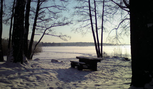 Parkbänk vid Vallentunasjön under vintertid.