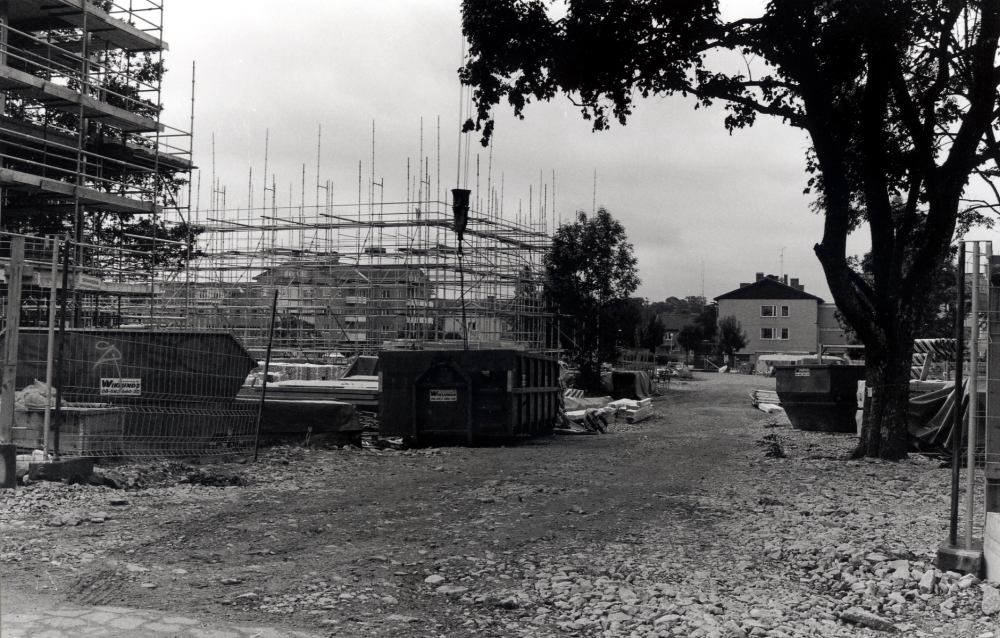 Byggarbetsplatsen i de s k Trädgårdskvarteren vid Mörbyvägen. I bakgrunden syns bostadshusen vid Allévägen.  Genom byggnadsställningen skymtar Alléhuset